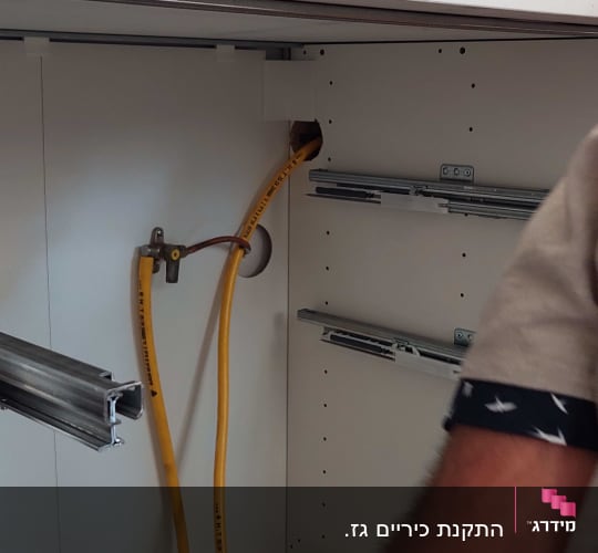 צינורות גז צהובים ומחברים בארון מטבח
